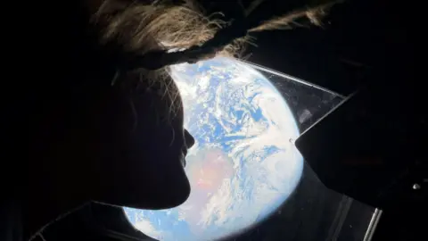 Astronaut Christina Koch watching Earth from the Orion spacecraft. 