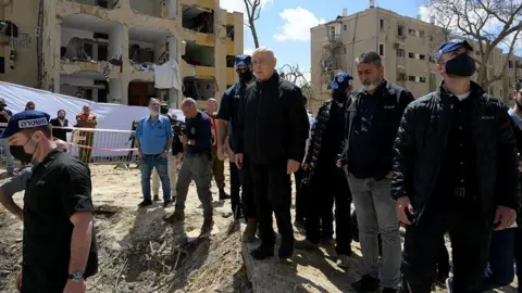 Getty Images Israeli Prime Minister Benjamin Netanyahu inspects damage at a site hit by a missile during an Iranian retaliatory attack in Arad, Israel, on March 22, 2026.
