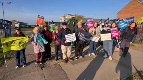 NASUWT South West NASUWT South West members stood outside the blue gates of Budmouth Academy with their banners.