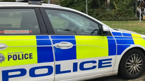 A white police car bearing the South Yorkshire Police crest