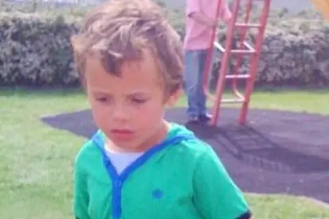 Levi Lewis A young boy in a green top in a playground
