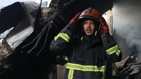 A firefighter looks on at the site of an Israeli strike carried out on Wednesday, in Al-Mazraa in Beirut, Lebanon, April 9, 2026.