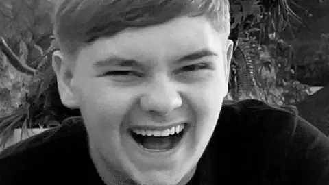 A black and white photo of teenager Harvey Willgoose laughing