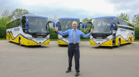 A man standing in front of coaches