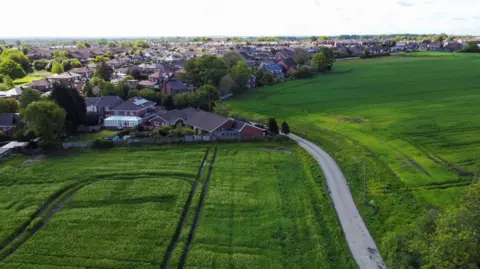 REU A drone view looking towards fields and houses in Ashton-in-Makerfield.