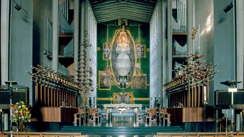 Getty Images The nave of the cathedral, or the central part of the building, with a view of the tapestry, Christ in Glory, by Graham Sutherland, which depicts the risen Christ in an aura of light in heaven.