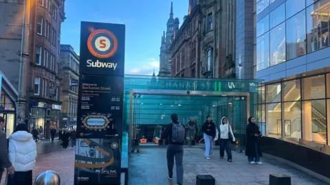 Entrance to Buchanan Street Subway station, on a busy main shopping street with a large Subway sign outside.