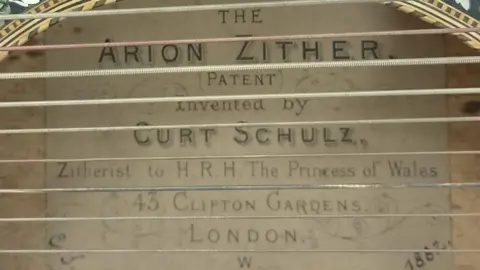 Air Ambulance Wigston A look inside the opening in the body of the instrument. Written inside is: The Arion Zither [PATENT] Invented by Curt Schulz, Zitherist to H.R.H The Princess of Wales 43, Clifton Gardens, London, W. 1882