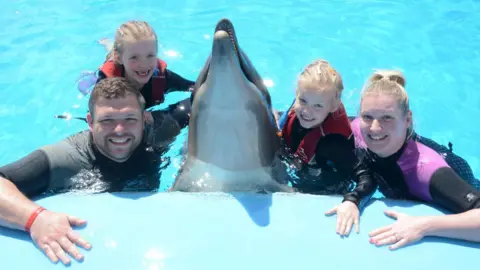 Laura and Paul Melling swimming with dolphins with their daughters in Egypt
