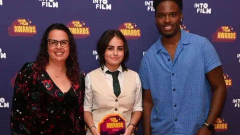 Documentary winner Rosie is standing with presenters Sally El Hosaini and Amani Simpson.
