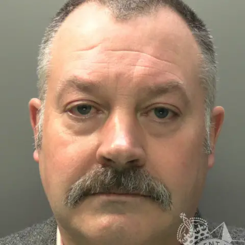 Gwent Police A custody image of Griffiths. He has short grey hair and a grey moustache. 