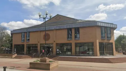 Lincoln Magistrates' Court building. The sky is blue with clouds.