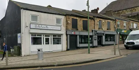 Google A Google Street View screenshot of K2 and The Union in Consett. The two units are next to each other on the lower levels of terraced buildings, flanked by other shops and commercial units, such as Subway. Both have grey panelling around the windows and doors where the shop signs are displayed.