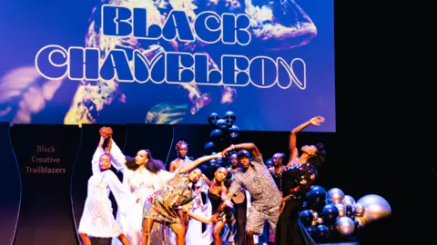 BlackCreativeTraiblazers People dressed in colourful clothing on a stage in Manchester