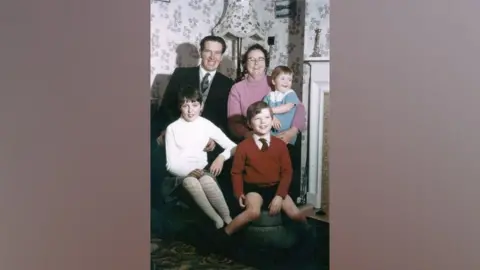 Zirins family handout Karlis Zirins sitting with his wife and three children at home in about 1967