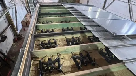 SBU Picture shows drones inside wooden boxes with retractable roofs
