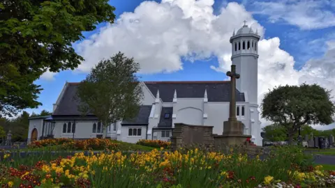 The island's crematorium, a large white building with tower surrounded by gardens.