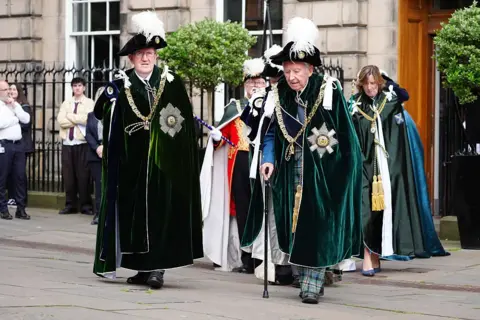Getty Images Lord Robertson of Port Ellen and Lord Steel of Aikwood in the green robes of the Order of the Thistle, walk though Parliament Square.