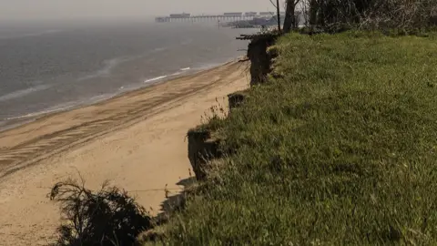 Anne Jones A cliff edge, showing jagged points where the sandy land has broken away.