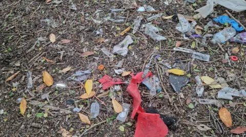 Peterborough Litter Wombles Pieces of rubbish scattered around on the ground, including plastic wrappers and syringes.