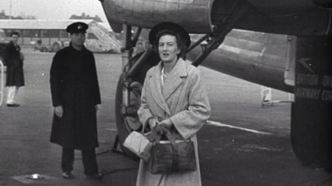 Mary Leakey in front of a plane at Heathrow Airport.