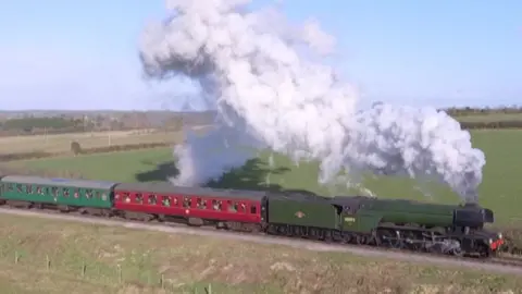 The Flying Scotsman with a head of steam travelling through the Hampshire countryside