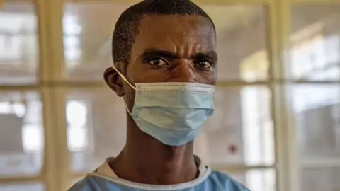 BBC A nurse in green scrubs wearing a face mask at Lwiro Community Hospital, DR Congo