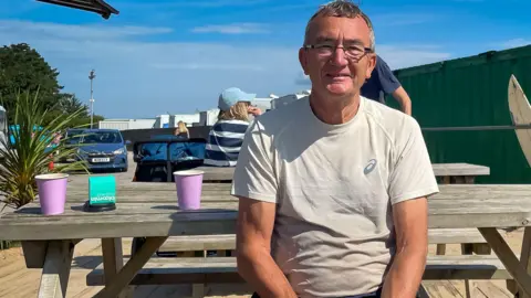 man in tee shirt on a park table