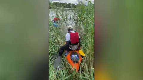 YANA Man kayaking through thick reeds
