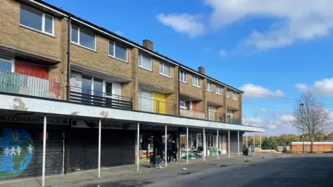 Simon Thake/BBC 
An empty shopping centre with many shutters down
