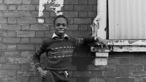 John Dean A young boy posing outside a house in Nottingham