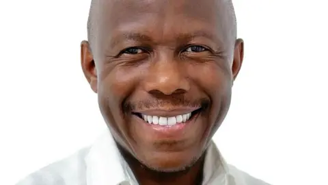 The Citizen Humphrey Polepole in a white shirt