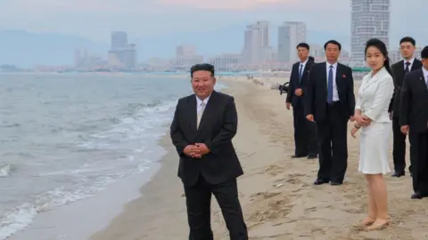 KCNA A photo released by the official North Korean Central News Agency (KCNA) shows North Korean leader Kim Jong Un (L) and his daughter Kim Ju Ae (3-R) standing on a beach during a ceremony marking the opening of the Wonsan Kalma Coastal Tourist Zone in Wonsan, North Korea, 24 June 2025 (issued 26 June 2025).