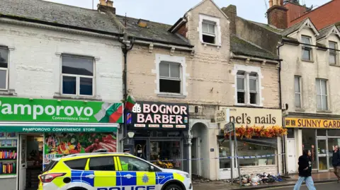 BBC/Sam Dixon-French A police car parked outside the scene of a fire in a flat above several shops in Station Road, Bognor Regis.