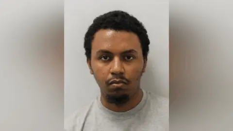 Metropolitan Police A custody image of Jala Debella in a grey t-shirt. 