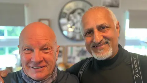 Kevin Sargeant and Mo Shaikh are smiling at the camera. Mo has his arm round Kevin.