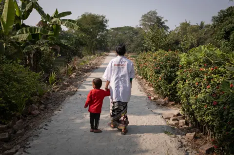 Swastik Pal a kissing mother that care a boy in a crèche of annegio prevention in SunDarbanban