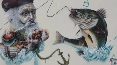 Local Democracy Reporting Service Street art showing a fisherman's head with his long white beard on a boat and a hook catching a fish which was painted on a building on Topping Street, Blackpool. 