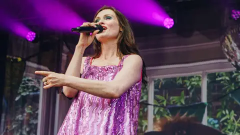 Harris Tomlinson-Spence/Truck Festival Sophie Ellis-Bextor singing on stage, wearing a purple dress.