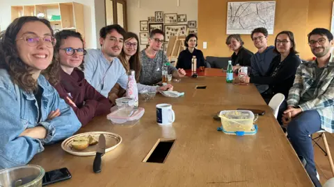 A group of people sit around a table