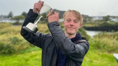 Last year's winner Finn Dower holding up the trophy