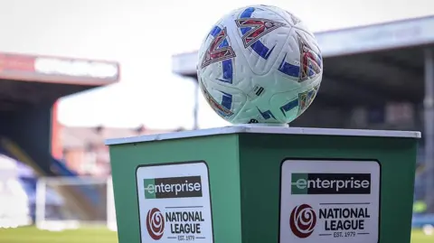 A football balanced on a green plinth bearing the name of the Enterprise National League
