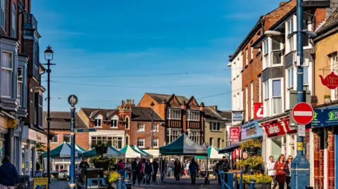 Getty Images A picture of a market town, with brick buildings and blue skies