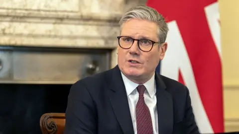 Prime Minister Keir Starmer looks on in front of a Union flag in Downing Street