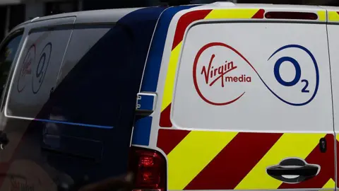 Getty Images A white Virgin Media O2 van with red and yellow high-visibility stripes on the back as well as the company's red and blue logo. 