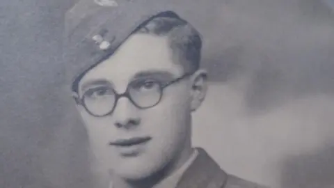 Image supplied A young Alan in 1942. He is wearing a military uniform with glasses.