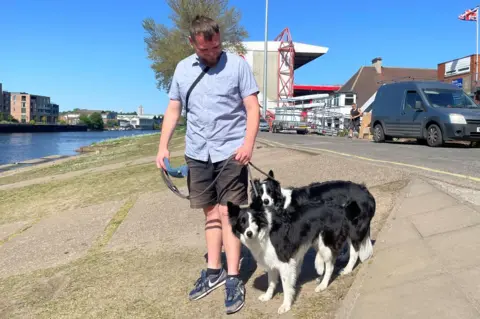 Jake Kingston-Thundercliffe walking his two dogs along the south bank of the River Trent