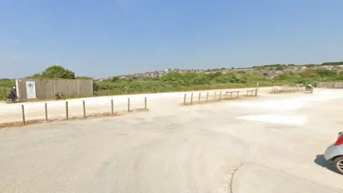 Google An empty car park surrounded by hedges