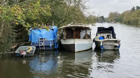Environment Agency Three boats on the Thames in West Molesey, Surrey.