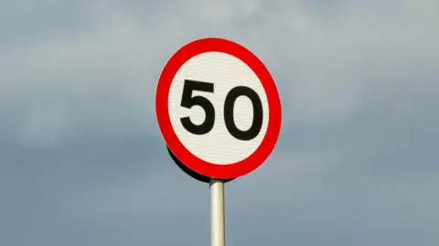 Getty Images A circular sign with a red surround with "50" written in black numbers on a white background.